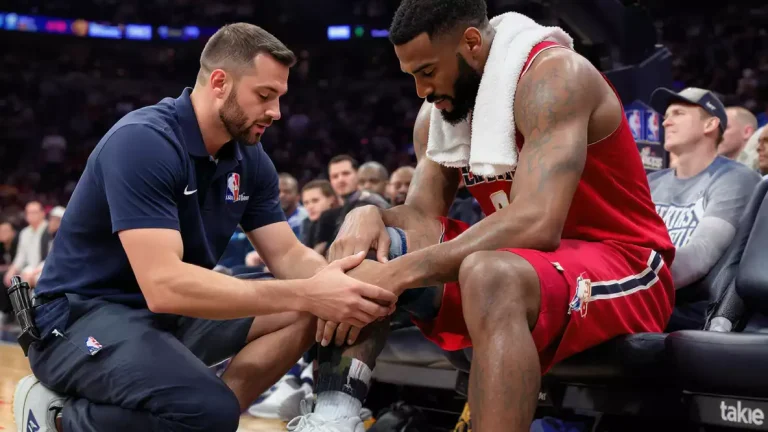 NBA-medische staf bij de bank praat met een speler over zijn fysieke status tijdens een wedstrijd